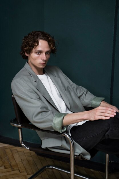 Side view young man posing on chair