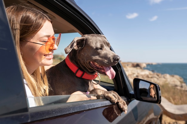 Free photo side view young woman and dog going on a trip