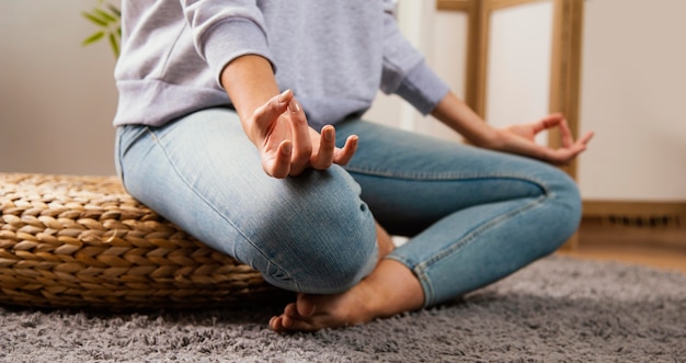 Side view of young woman doing yoga at home