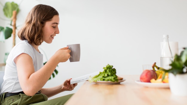 Side view young woman enjoying coffee