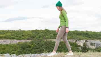 Free photo side view young woman enjoying walking outdoors