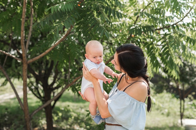 Side view of young woman playing with baby in the garden