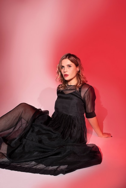 Side view young woman posing in black dress