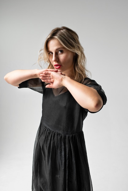 Side view young woman posing in black dress