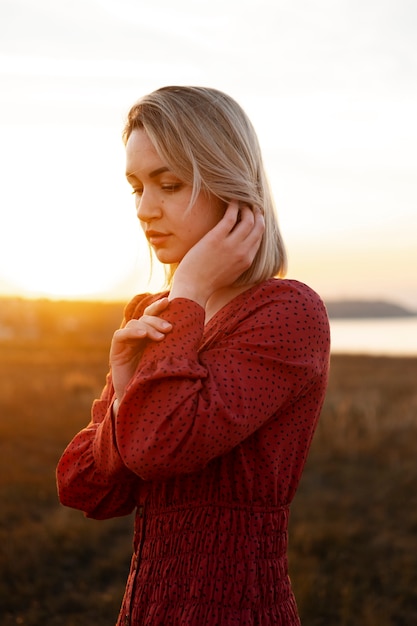 Free Photo side view young woman posing at sunset