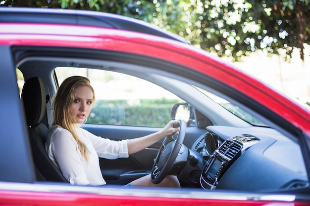 Free photo side view of a young woman sitting inside car