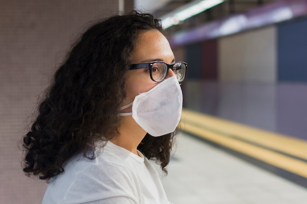 Side view young woman with medical mask waiting