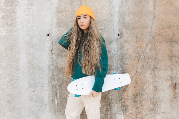 Free photo side view young woman with skateboard