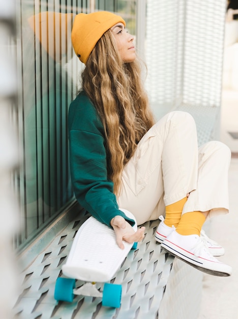 Free photo side view young woman with skateboard