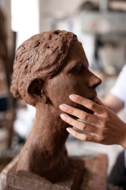 Free Photo sided view hands clay sculpting