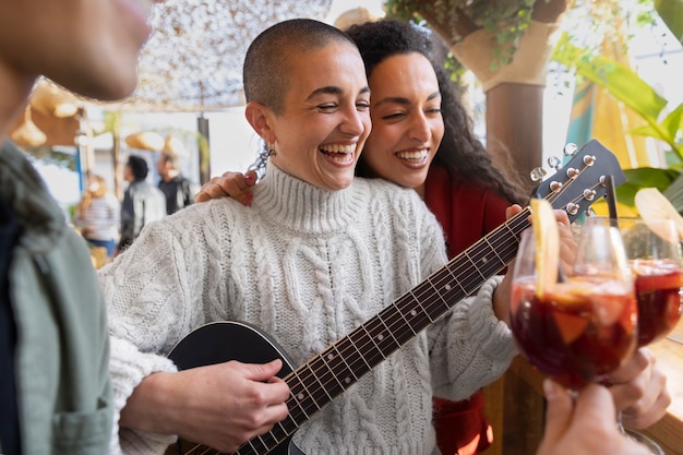 Free photo sided view happy woman playing the guitar