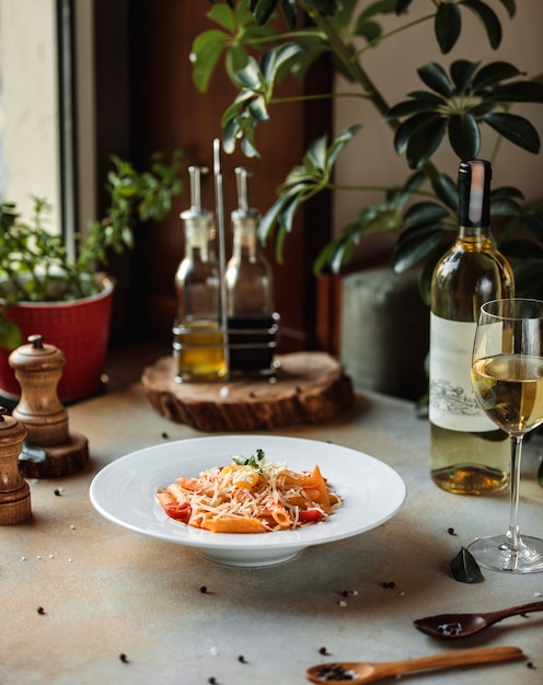 Sideview of pasta with tomato sauce and parmesan cheese in white bowl