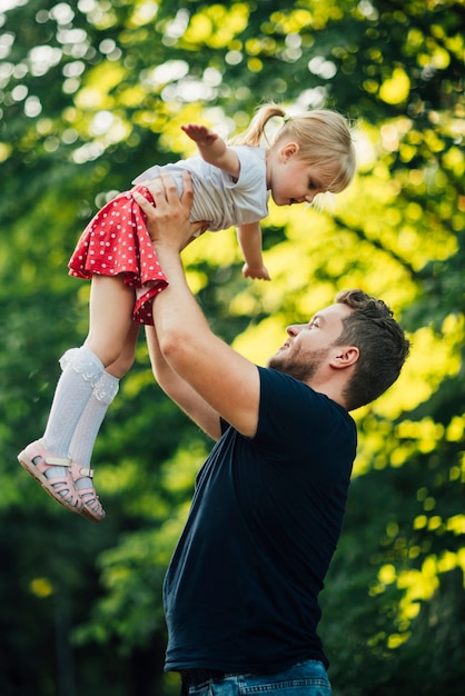 Free photo sideways father and daughter playing in park