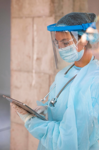 Free Photo sideways female doctor looking at a clipboard