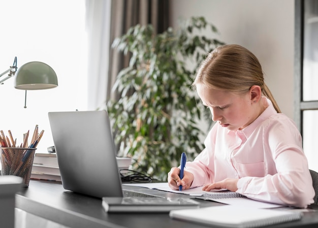 Sideways little girl participating in online class