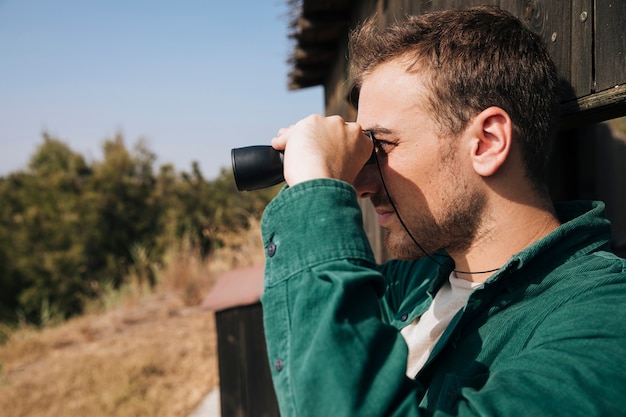 Free Photo sideways man looking through binoculars