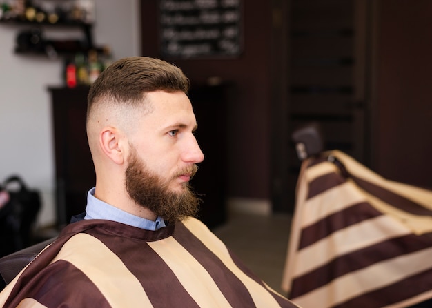 Free photo sideways man waiting for a new haircut