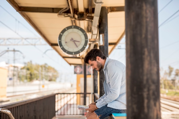 Sideways man waiting for train