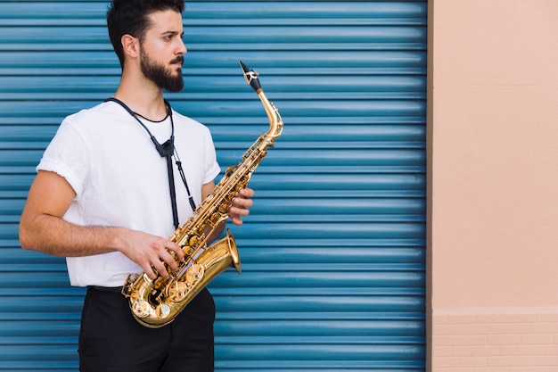 Free Photo sideways medium shot musician posing with saxophone