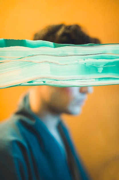 Free photo sideways model posing with green paint covering his eyes