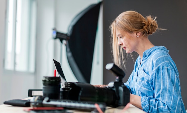 Free Photo sideways photographer woman working on her bench