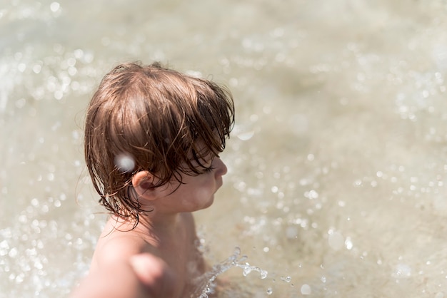 Sideways top view child playing in water