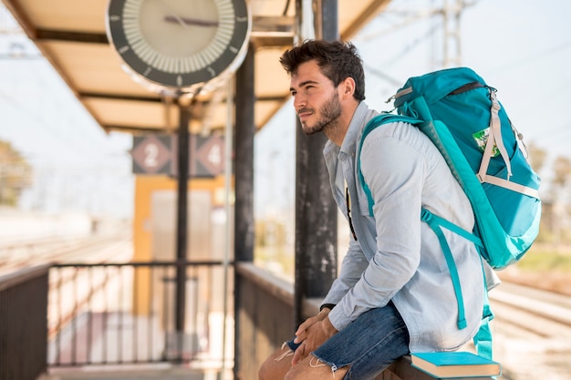 Sideways traveler waiting for train