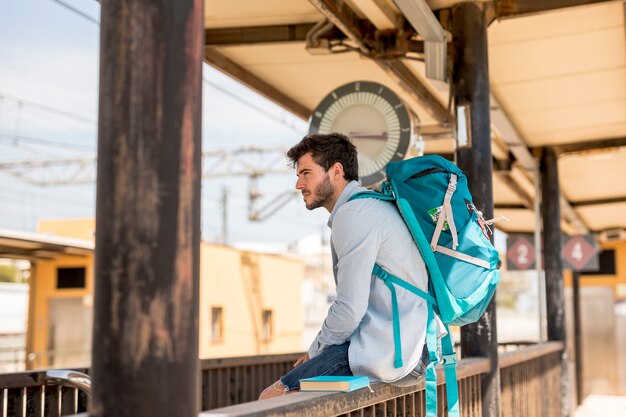 Sideways traveler waiting for train