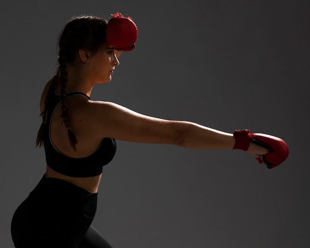 Sideways woman punching with box gloves