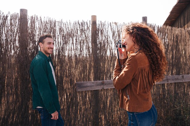 Sideways woman taking photos of man