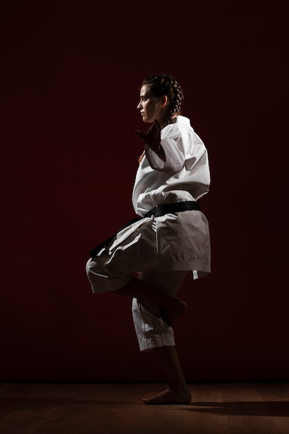 Free photo sideways woman in white karate uniform