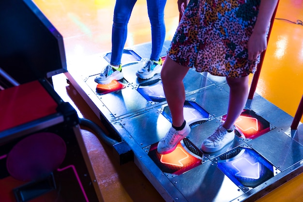 Free photo sideways women playing dancing arcade