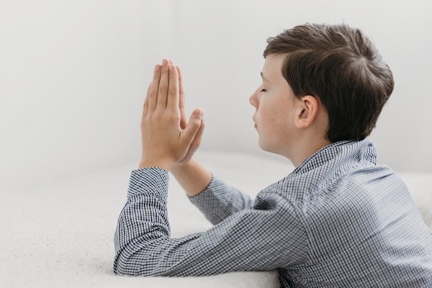 Sideways young boy praying peacefully