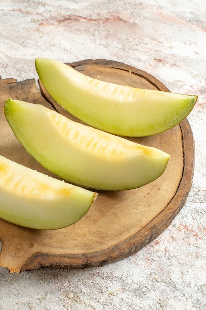 Free Photo sidewise shot of melons on wooden platter on white marble