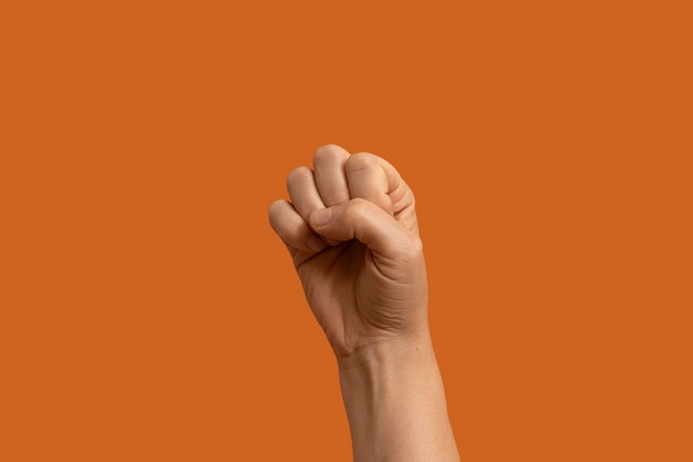 Free photo sign language symbol isolated on orange