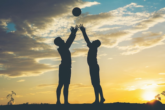 Silhouette of children play soccer football