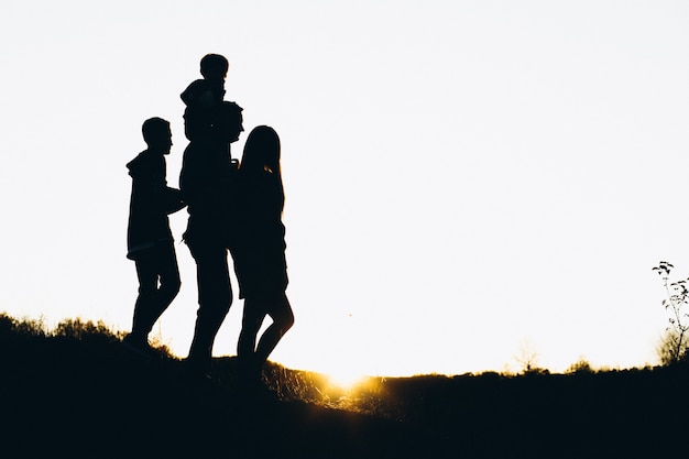 Silhouette of a family walking by the sunset time