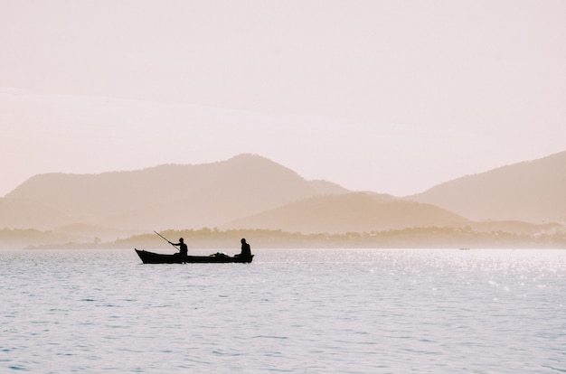 Free photo silhouette of fishermen in a small boat