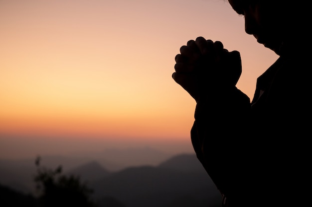 Free photo silhouette of girl praying over beautiful sky background.