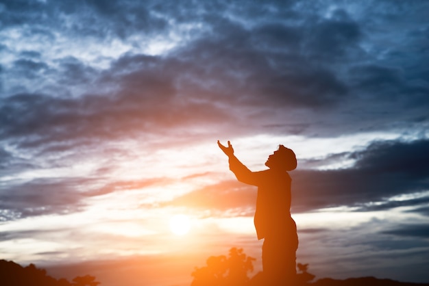 silhouette of handsome asian man praying.