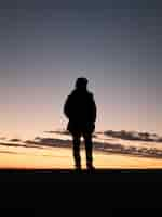 Free photo silhouette of a lonely person enjoying the beautiful view of the sunset