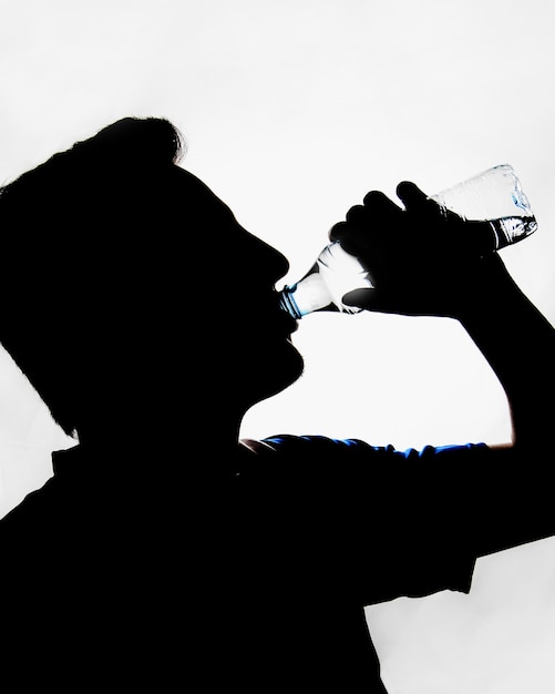 Silhouette of man drinking water