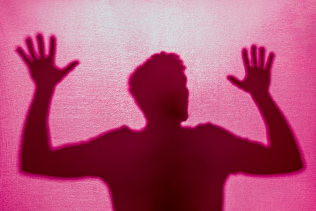 Free photo silhouette of man trapped behind cloth