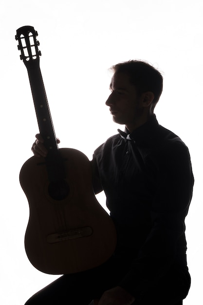 Silhouette of a man with acoustic guitar