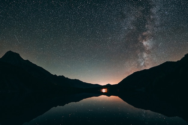 Free Photo silhouette of mountain and calm body of water