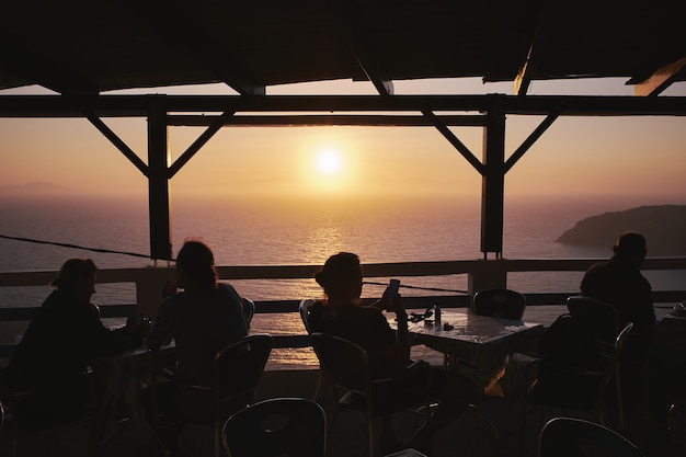 Free photo silhouette of people enjoying their time at sunset in a cafe at potamos beach, greece