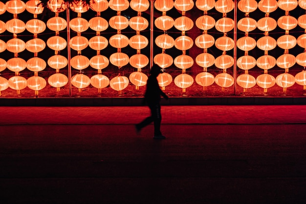 Free photo silhouette of a person walking near the lantern lamps at ngiht in dalian, north-east china