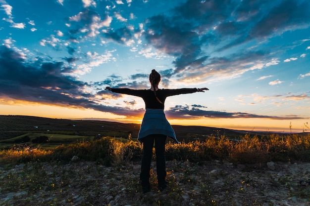 Free photo silhouette shot of a young female hiker in the countryside in spain