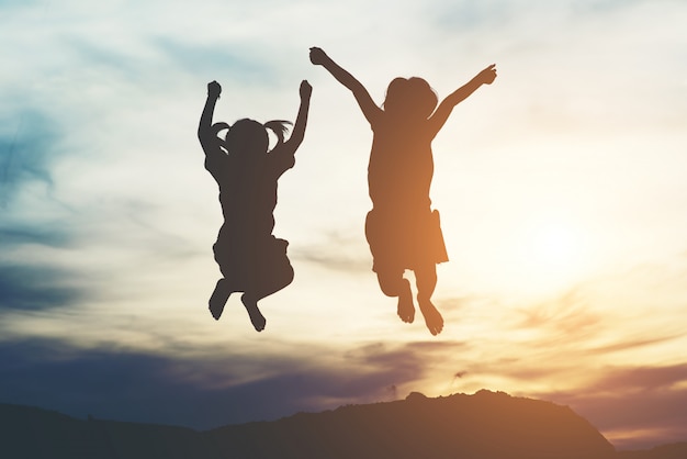 Silhouette of two girl having fun in nature