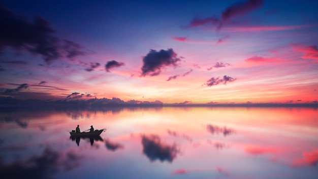 Silhouette of two person sitting on boat during daytime